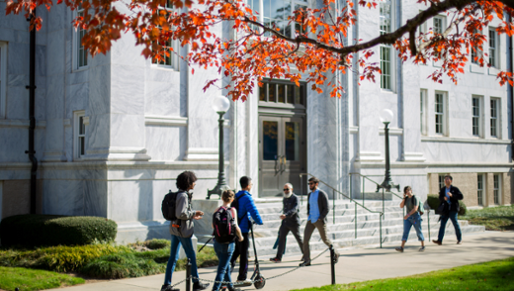 students on quad in front of marble building in the sunshine