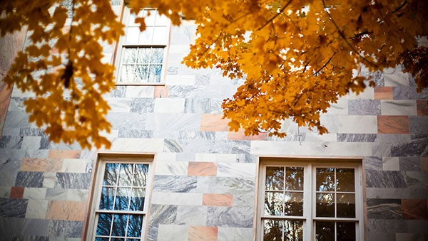 pink marble Quad building juxtaposed with fall leaves